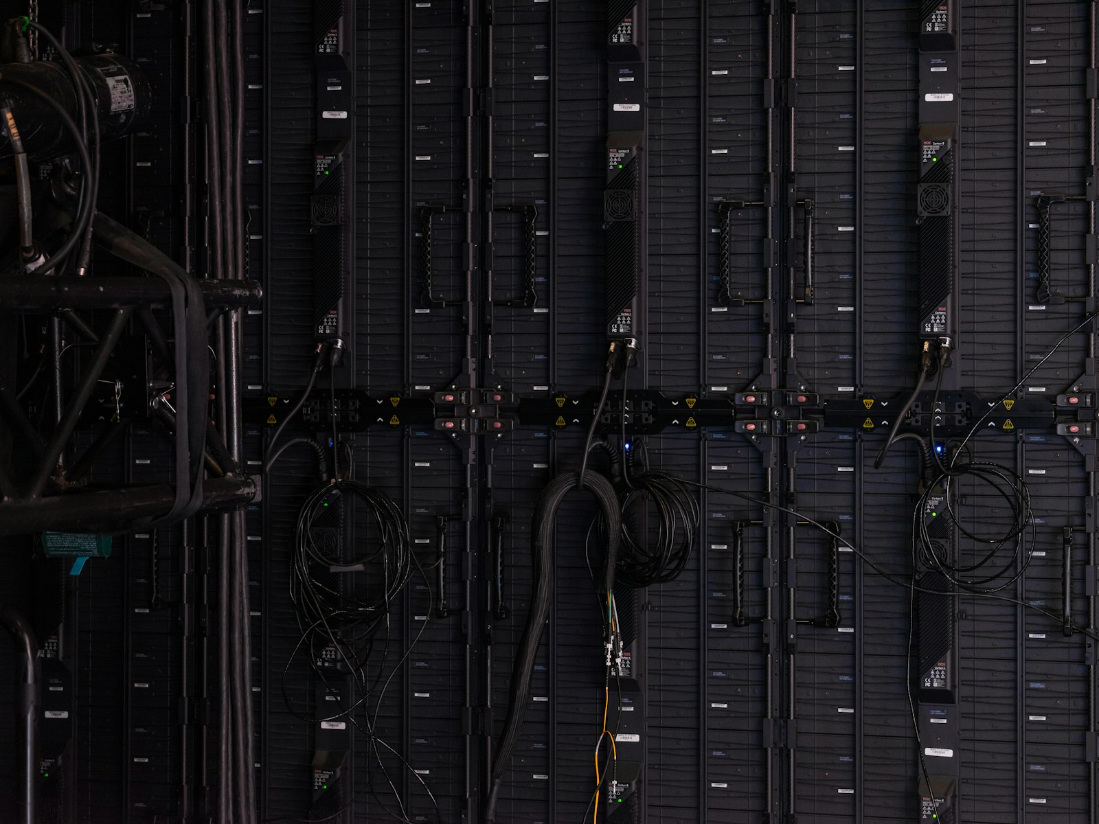 Rows of illuminated servers inside a dark data center corridor.